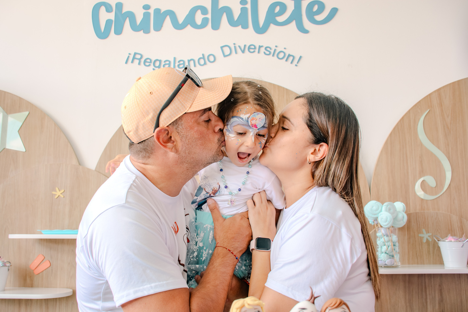Papás dando un beso a su hija durante su celebración