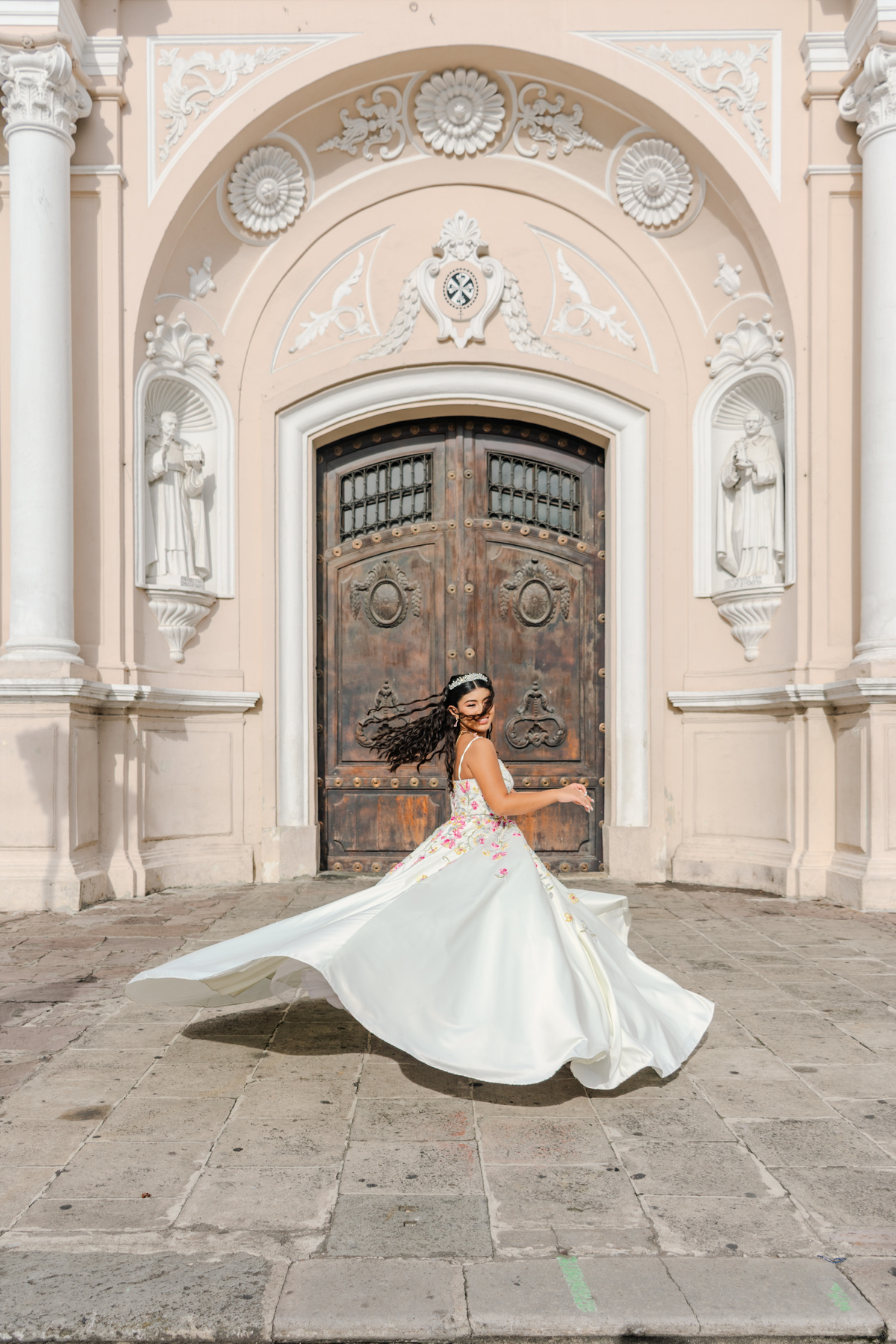 Retrato con vestido blanco frente a una iglesia